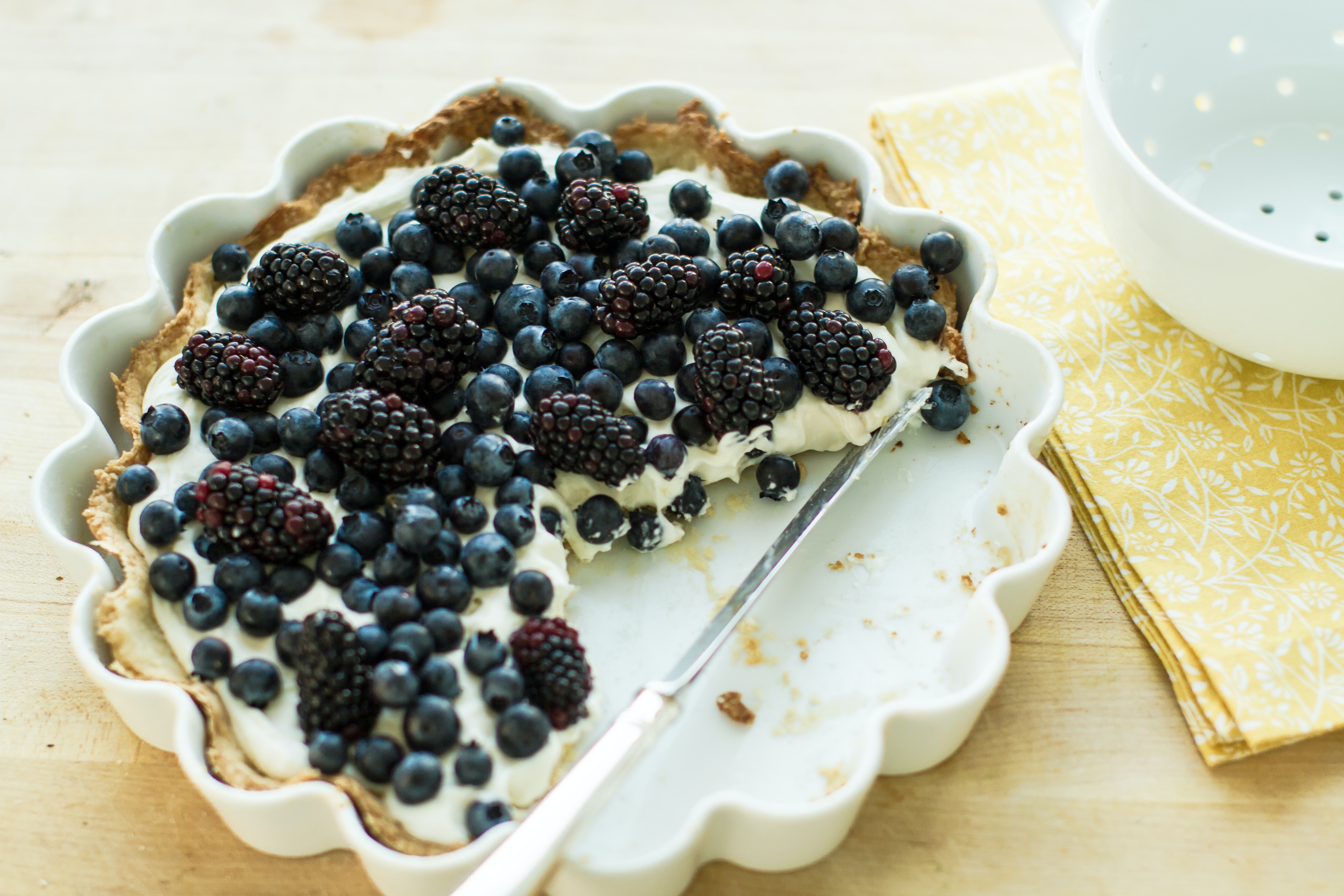 A whole cheesecake with blueberries on top 